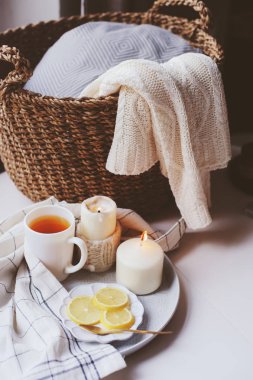 Kış sabahı evde rahat. Sıcak çay limon, mumlar, sepet ve modern metalik iç Ayrıntılar kazak ördü. Natürmort kompozisyon, Danimarkalı hygge kavramı