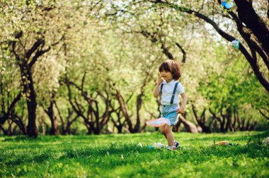 mutlu 3 yaşında çocuk çocuk güneşli Bahçe veya park yürüyüş net kelebekler yakalamak. Bahar ve yaz açık hava etkinlikleri, mutlu çocukluk kavramı.