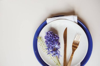 Plaka, altın çatal bıçak takımı ve kopya alanı beyaz zemin üzerine sümbül çiçek Paskalya tatili şenlikli yemek masası. Düz yatıyordu, en iyi görünümü