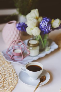 Sabah kahvesi, Bahar süslemeleri evde çiçek ve aromatik mumlar ile modern İskandinav tarzı tablo. Yavaş yaşam ve hygge kavramı
