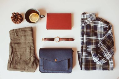 hipster or traveller woman casual fashion set flat lay. Plaid shirt, blue cross body bag  and khaki pants on white background with cup of tea. Stylish outfit top view. clipart