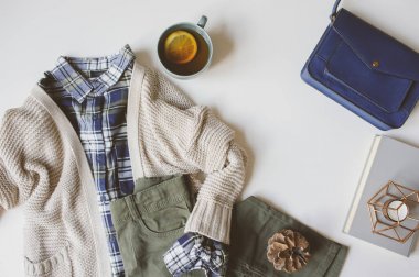 rahat sonbahar kadını rahat kıyafet seti, düz kopya alanı ile yatıyordu. Ekose gömlek, süveter, mavi çapraz ceset torbası ve haki pantolon beyaz arka plan üzerine örme. Şık moda, üstten görünüm.