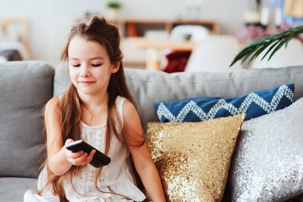 在舒适的沙发上在家看电视的儿童女孩 现代斯堪的纳维亚内部 孩子和电视概念 — 图库照片