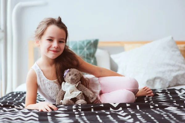 可爱的快乐的小女孩在家里放松 在她的房间在清晨的床上 微笑的孩子与泰迪熊享受舒适的周末 — 图库照片