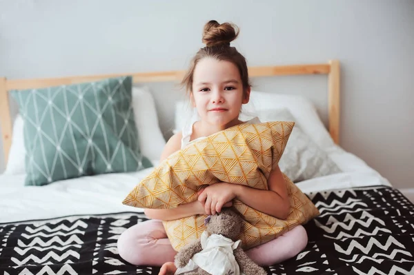 快乐的孩子女孩坐在床上拥抱枕头 清晨醒来或睡觉 舒适的房间里享受周末的孩子 — 图库照片
