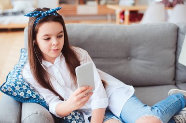 akıllı telefon kullanan evde rahat kanepede rahatlatıcı ve müzik, dinlemek mutlu varoluş kız