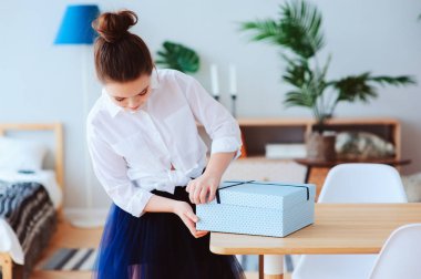 doğum günü ya da kadının evde modern İskandinav iç, hazırlama veya unwraping hediye gün poz için hediye ile mutlu bir çocukluk kız.