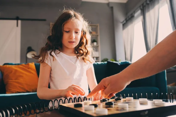 在家里和爸爸一起玩跳棋的孩子女孩 父亲与质量家庭时间概念 — 图库照片
