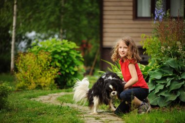 Yaz bahçesinde açık onun spaniel köpeği ile oynarken mutlu 8 yaşında çocuk kız