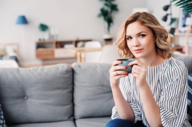 Genç başarılı iş kadını evde rahat kanepede rahatlatıcı. Modern İskandinav iç, başlangıç, ev ofis kavramı. 