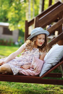 güneşli Bahçe şezlong üzerinde rahatlatıcı, yaz tatillerini açık zevk çocuk kız