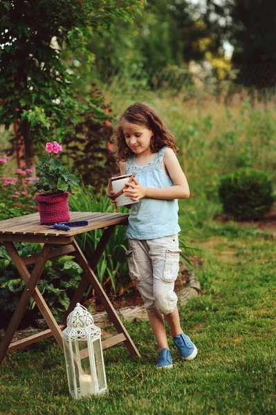 ロマンチックな夜の庭でキャンドル ホルダーと歩いている少女を子供します 夏の庭や裏庭を飾る 子供の夏休みに自然を愛することを学ぶ — ストック写真