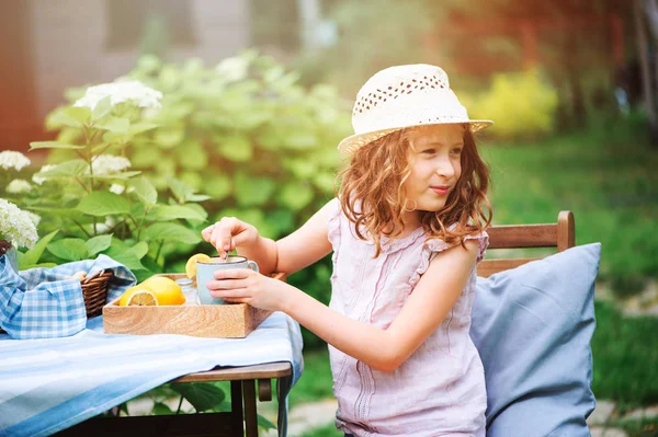 朝の夏の庭のレモンでお茶を飲んで幸せな子供女の子 — ストック写真