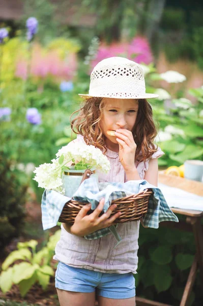 背景にアジサイの花を咲く咲く庭の暖かい夏の日を楽しむ帽子で幸せな子供女の子 — ストック写真