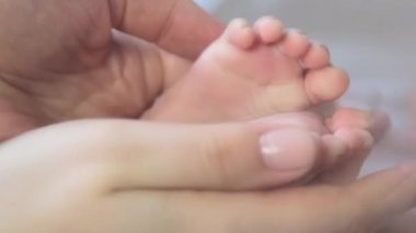 Bebe ayak anne elinde. Yeni doğan bebek ayakları üzerinde eller yukarı