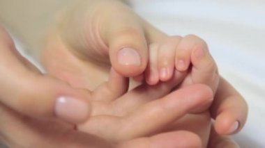Bebek el anne elinde. Yeni doğan bebek üzerinde kadın eller Closeup ver. Annelik güzel kavramsal video okşamak