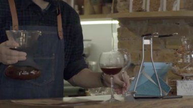 Gülümseyen genç bir barista adam Senfoni ile kahve dolduruyor.