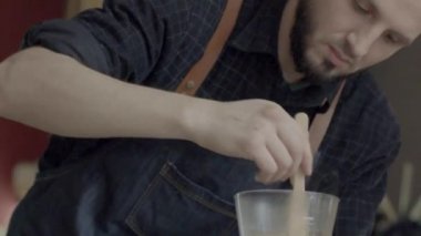 Genç bir beyaz barista hazırlamak kahve tesisler karıştırın
