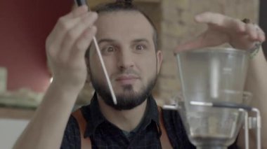 Pozitif Barista adam hazırlamak kahve tesisler sıcaklık alarak karıştırın,