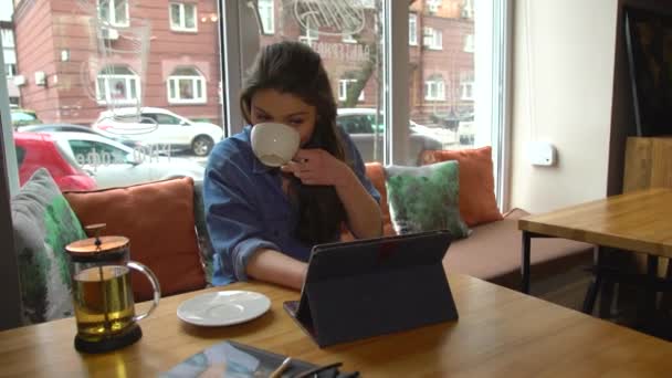 Happy young woman Surfing Internet On Tablet Touchscreen. Sitting In Cafe — Stock Video