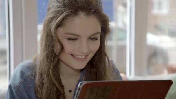 Young positieve Kaukasische vrouw surfen op een tablet. Close-up — Stockvideo