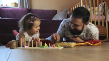 Babam evde küçük kızıyla Montessori oyuncaklarıyla oynuyor.