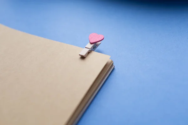 Wasknijpers met harten zijn Kladblok. Blauwe achtergrond papier — Stockfoto