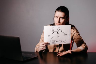 Kız İngilizce öğretiyor ve işaretleri kullanarak cümleler kuruyor. Çevrimiçi okulda öğretmenlik için yenilikçi pedagoji. İnternette yeni bir İngilizce kursu mevcut..