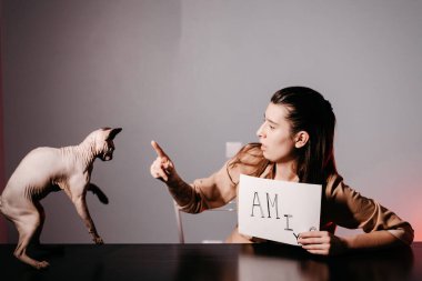 İngilizce öğreten ve kediyle işaret dilini kullanan kız. Çevrimiçi okulda öğretmenlik için yenilikçi pedagoji. İnternette yeni bir İngilizce kursu mevcut..