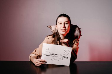 İngilizce öğreten ve kediyle işaret dilini kullanan kız. Çevrimiçi okulda öğretmenlik için yenilikçi pedagoji. İnternette yeni bir İngilizce kursu mevcut..