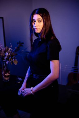 Genç ve güzel bir kız bir dairede karantinaya alındı. Alçak tuş ve mavi arkaplan