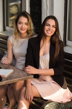 Mutlu kafe müşterileri güler, gülümser ve kameraya bakar..