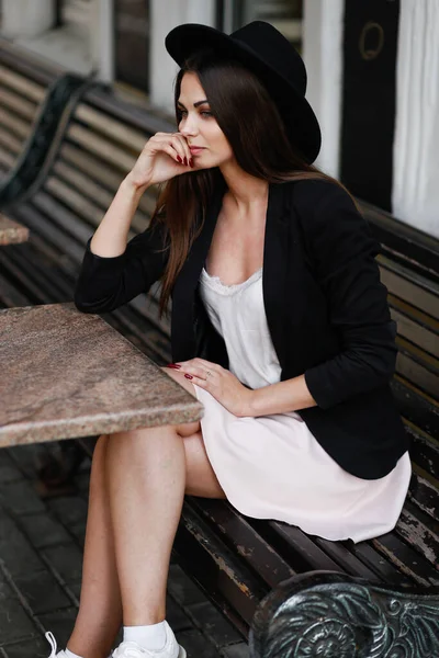 Une femme assise sur un banc en bois — Photo