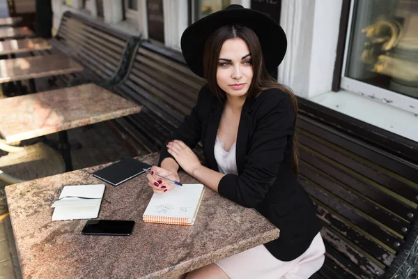 Une jeune fille écrivain écrit des articles pour un magazine de mode sur un verand d'été — Photo