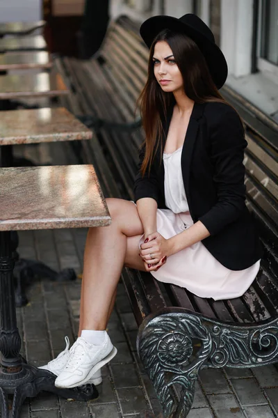 Une femme assise sur un banc en bois — Photo