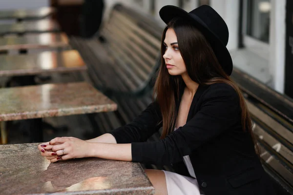 Une femme assise sur un banc en bois — Photo