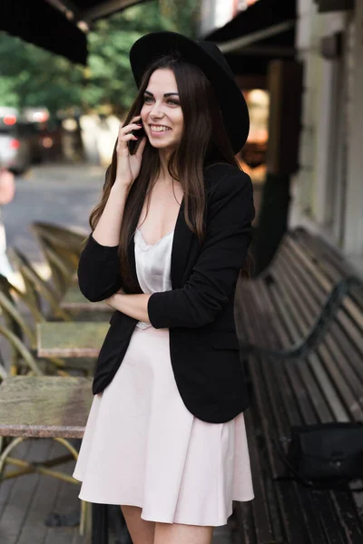 Une femme portant un chapeau noir et utilisant un téléphone portable — Photo
