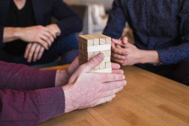 Erkekler modern bir tasarım ile lüks bir kafede jenga oynuyorlar.