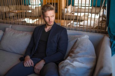 Başarılı genç sarışın adam modern bir çatı katında, nargile.