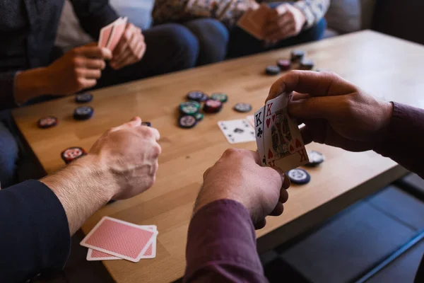 Vários homens estão jogando poker em um café, segurando cartas em suas mãos — Fotografia de Stock