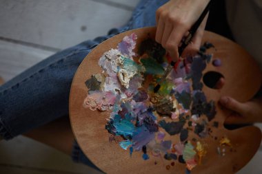 Bir kızın ellerinde boya paleti.