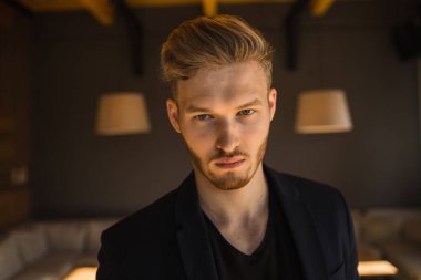 Başarılı genç sarışın adam modern bir çatı katında, nargile.