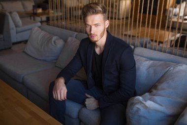 Başarılı genç sarışın adam modern bir çatı katında, nargile.