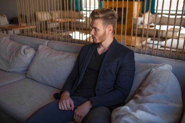 Başarılı genç sarışın adam modern bir çatı katında, nargile.