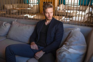 Başarılı genç sarışın adam modern bir çatı katında, nargile.