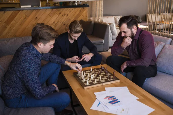Men play chess in a stylish loft cafe with a modern design