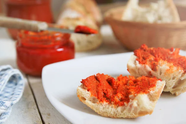 Einige typisch mallorquinische Sobrassada auf rustikalem Brot. Mahlzeit auf einem weißen Holztisch serviert — Stockfoto