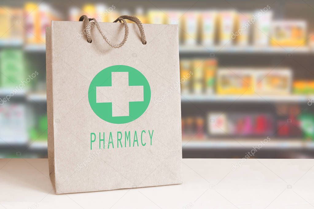 Recycled paper bag with a green Pharmacy logo in a drugstore. Empty copy space