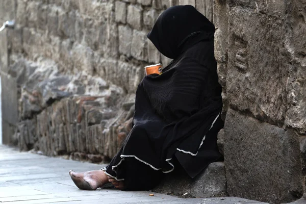 Poor woman begging sitting in the street. — Stock Photo, Image