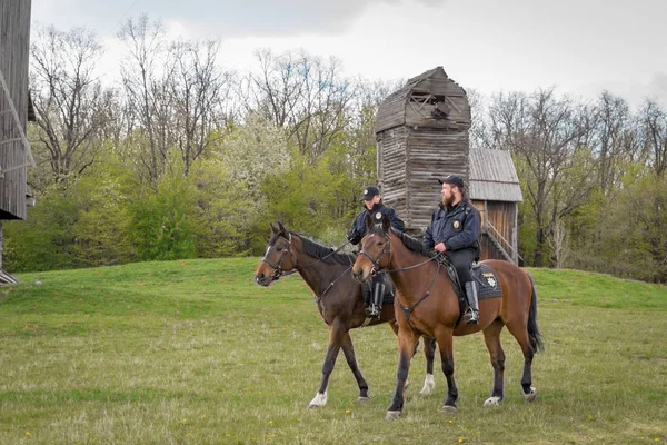 Kyiv, Ukraine - April 23, 2017: Policemen on horseback, a beautiful spring landscape, mounted police, horsemen in the countryside, outdoors. National Museum Pirogovo in the outdoors near Kiev. — Stock Photo, Image